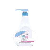Sebamed Baby Bubble Bath Camomile 500ml bottle beside a baby bath with foam bubbles
