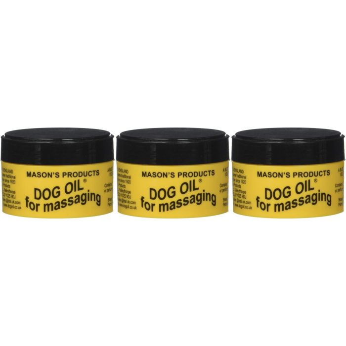 Masons Dog Oil Massaging Balm 100g tub on a wooden surface next to a dog
